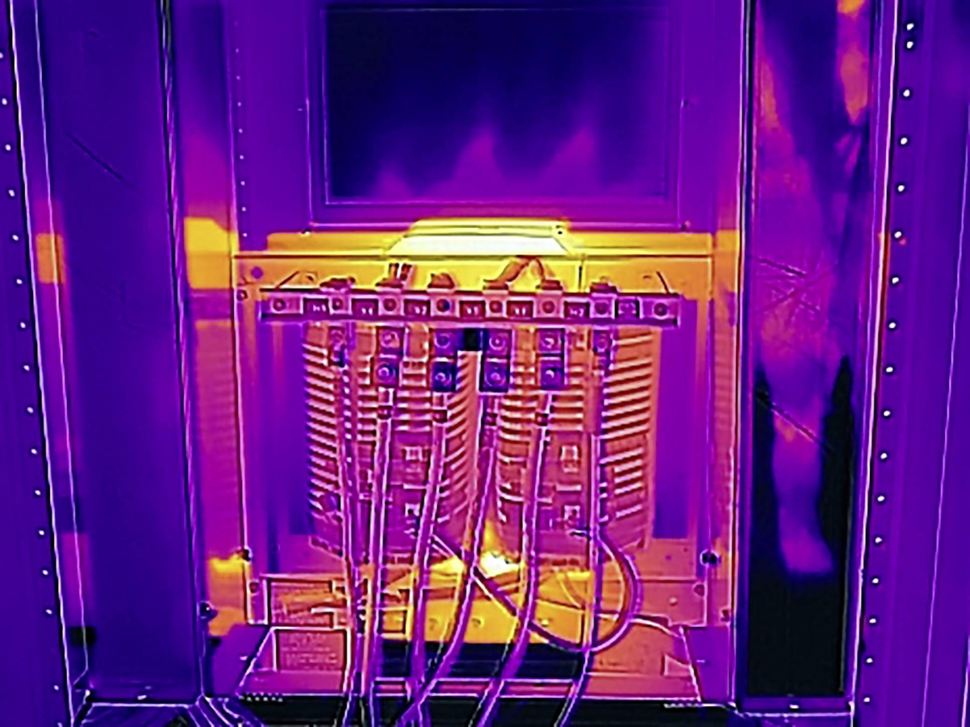 Egy hőkép egy elektromos elosztószekrényt mutat, amelyen színes jelzések szemléltetik a különböző hőmérsékleteket.