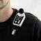 Egy férfi egy decibel-mérőkészüléket visel a pulóverén. A kijelzőn 82,4 dB látható, elemstátusz és mikrofonikon kíséretében.