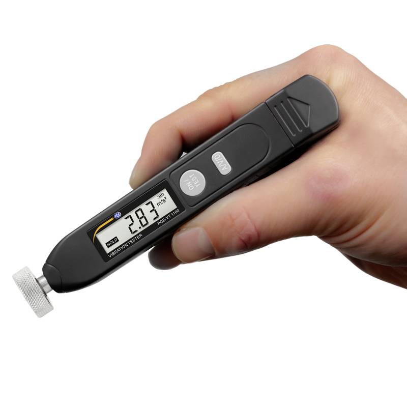 Egy kéz digitális mérőkészüléket tart, amelynek kijelzőjén '2.83' látható. A készüléknek ezüst, kerek feltéte van.