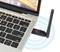 Egy laptop egy csatlakoztatott WLAN-adapterrel. A készülék rádióhullámokat sugároz, amelyek kék hullámvonalakkal érzékelhetők.
