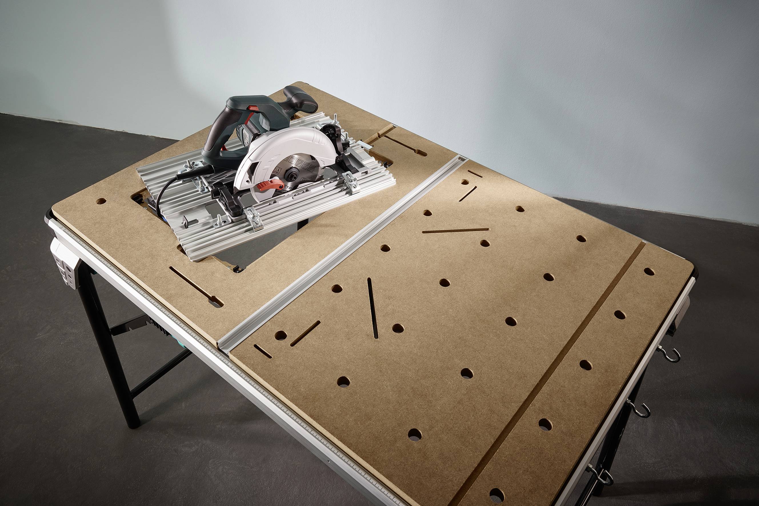 Körfűrész egy olajozott, lyukasztott munkaasztalon. A készülék üzemkész és egy stabil állványra szerelve.