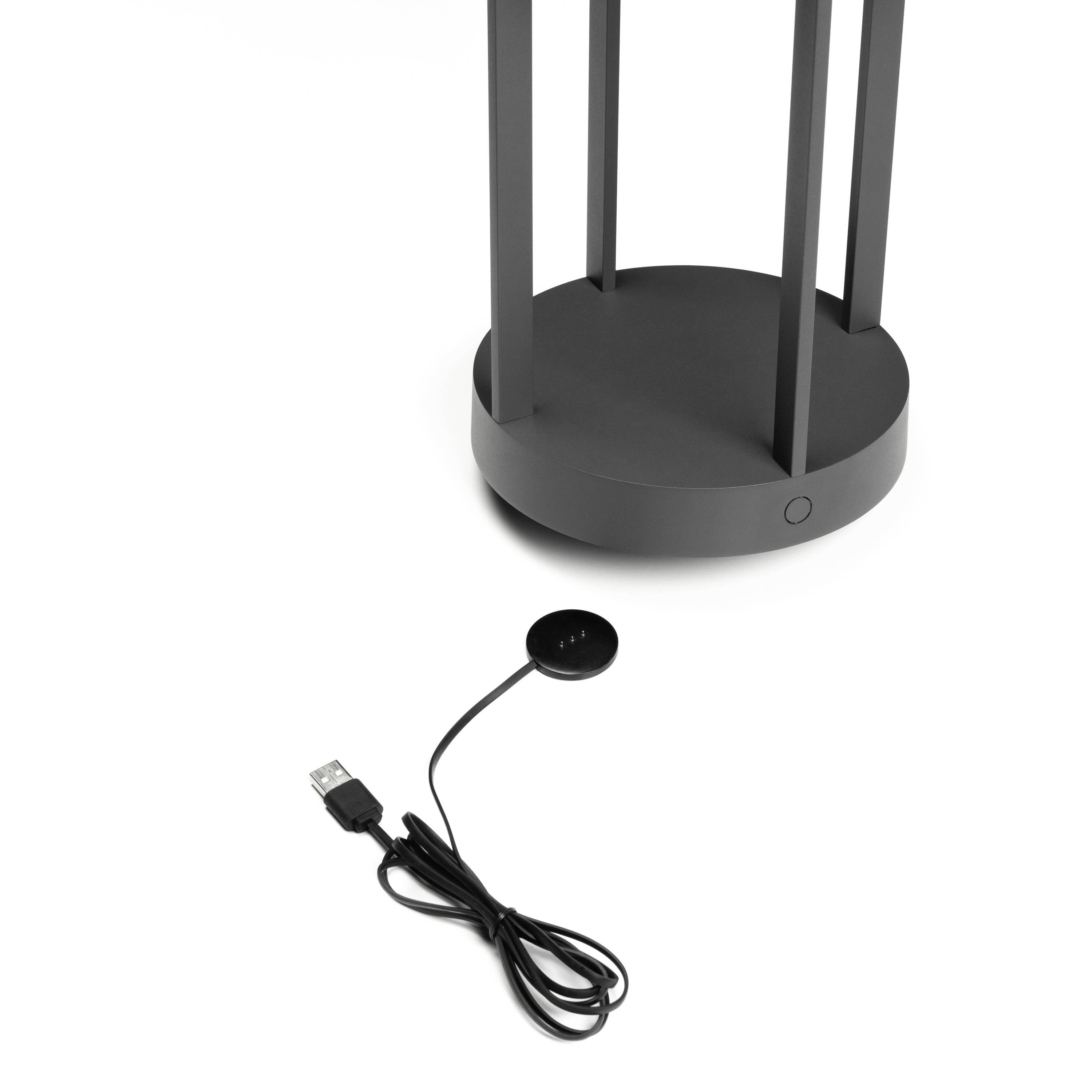 Egy vezeték nélküli töltő egy hengeres állvánnyal, mellette egy USB-kábel.