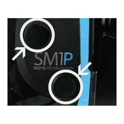 Két nyíllal ellátott köralakú gomb, a "SM1P SENS TECHNOLOGY" szöveg mellett, egy sötét felületen kék csíkkal.