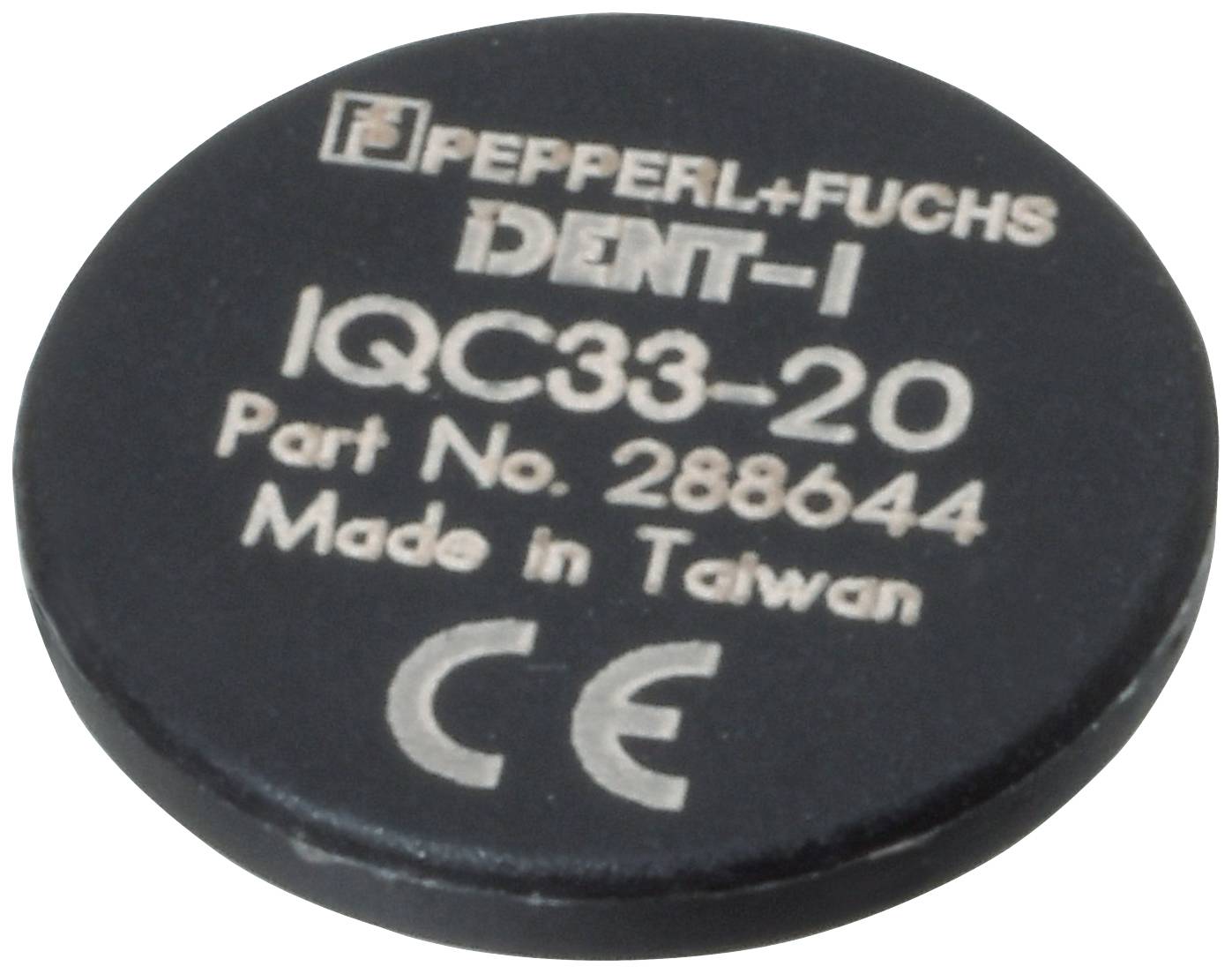 Kerek fekete transzponder a következő felirattal: 'Pepperl+Fuchs DENT-1 IQC33-20 Cikkszám 288644 Gyártva Tajvanon' és CE-jelöléssel.