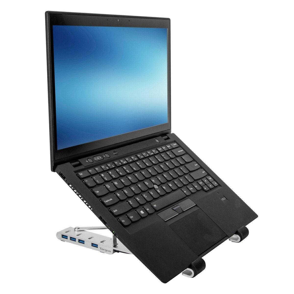 Egy fekete laptop ferdén áll egy ezüst állványon. A képernyőn kék átmenetes háttér látható.