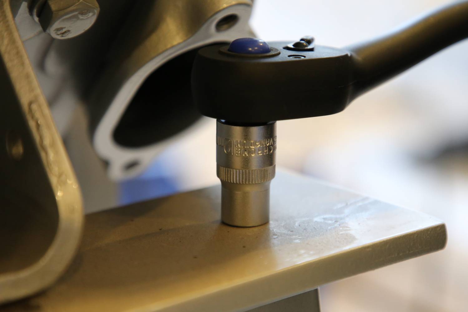 Egy mechanikus szerszámot alkalmaznak egy fémkötésre, amelyet a csavaron lévő racsnis emelő jelez.