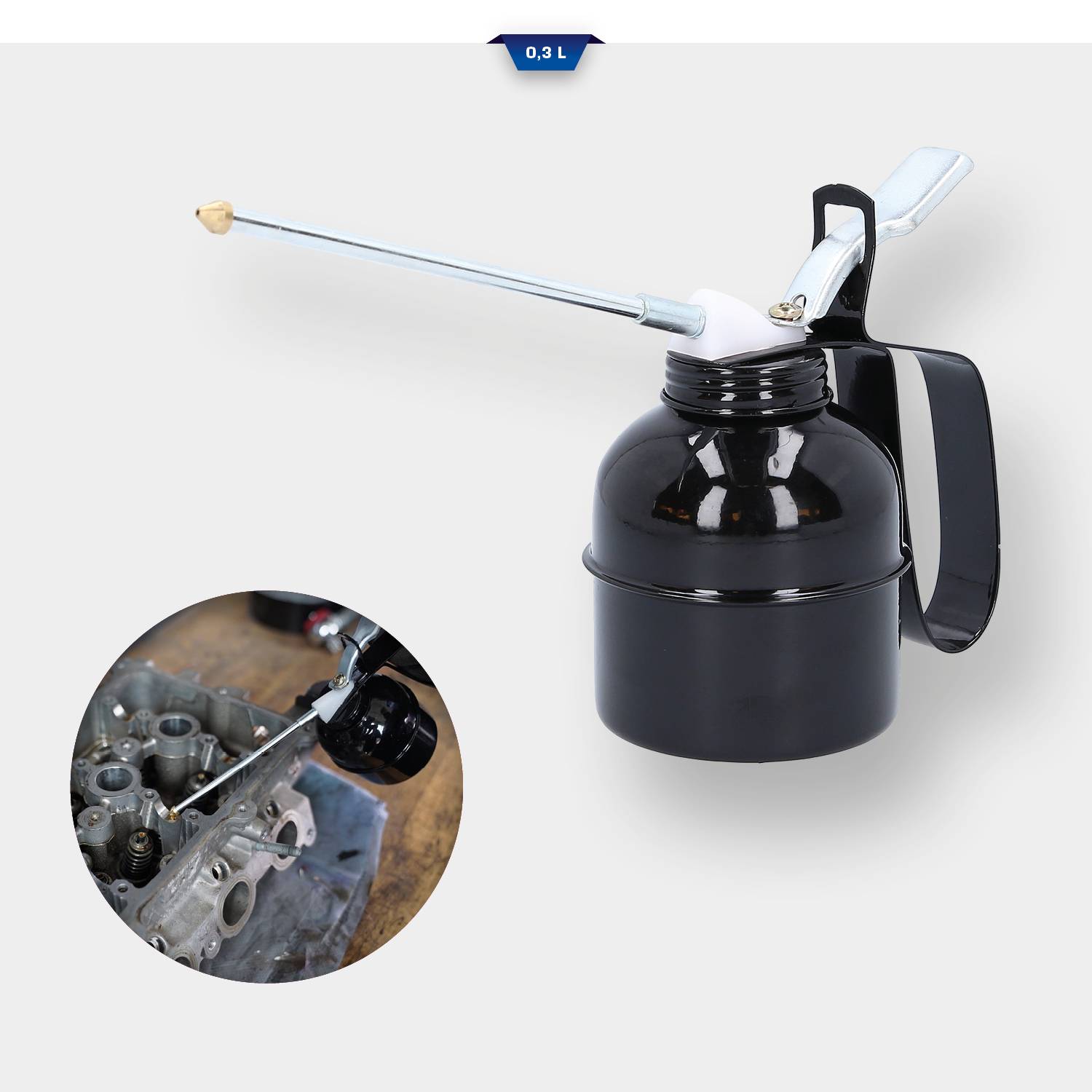 Fekete olajozópisztoly hosszú csőrrel, egy fémmotor kenésének folyamatát mutatja.