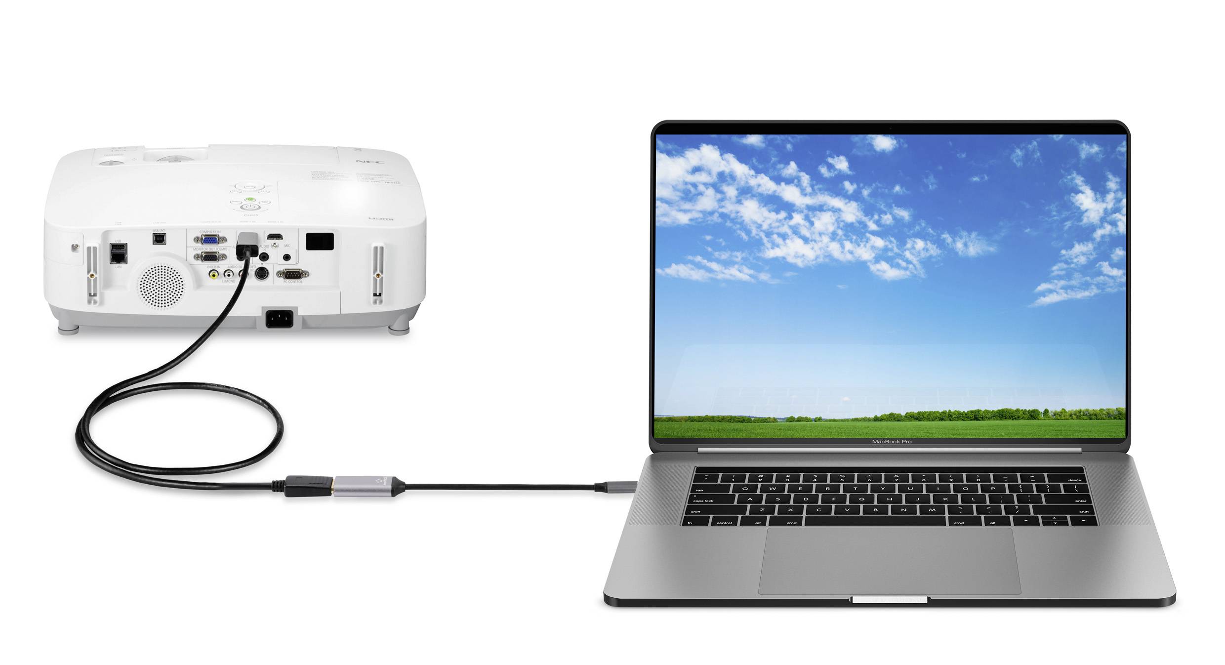 Egy laptop egy kábel segítségével csatlakozik egy projektorhoz. A laptopképernyőn egy táj látható kék éggel és zöld mezővel.