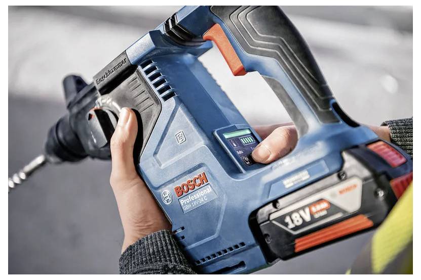 Egy személy egy kék Bosch Professional 18V fúrógépet tart, bemutatva annak vezeték nélküli kialakítását és ergonomikus markolatát, használatra készen.