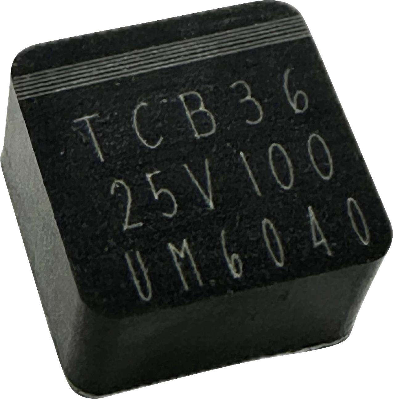 Egy fekete, négyzet alakú elektronikai chip, amelynek felső oldalán a 'TCB36 25V100 UM6040' felirat látható.