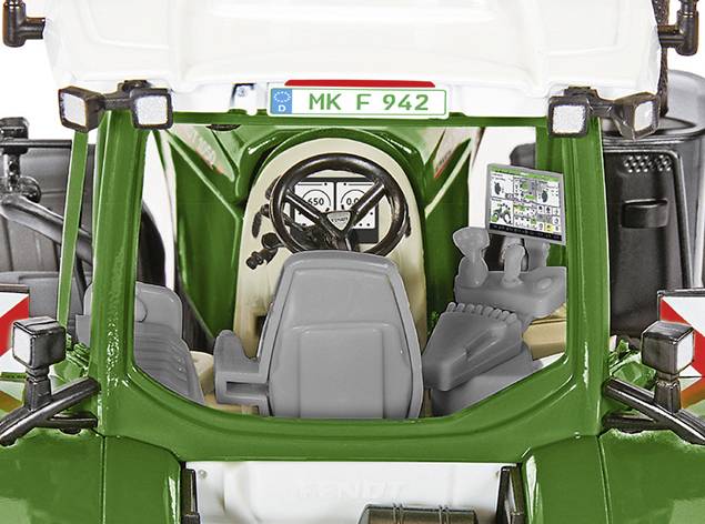 Egy zöld traktor elölnézetből fényképezve, látható vezetőfülkével és vezérlőpanellel. Rendszáma 'MK F 942'.