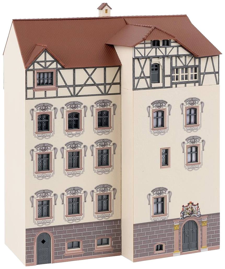 Egy történelmi épület faszerkezetes stílusú miniatűr modellje, több ablakkal és részletes díszítésekkel bézs háttér előtt.