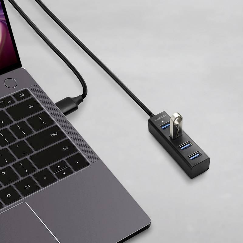 Egy laptop csatlakoztatva van egy USB-elosztóhoz. Az elosztónak négy portja van, amelyek közül az egyik egy USB-pendrive-ot foglal magában.