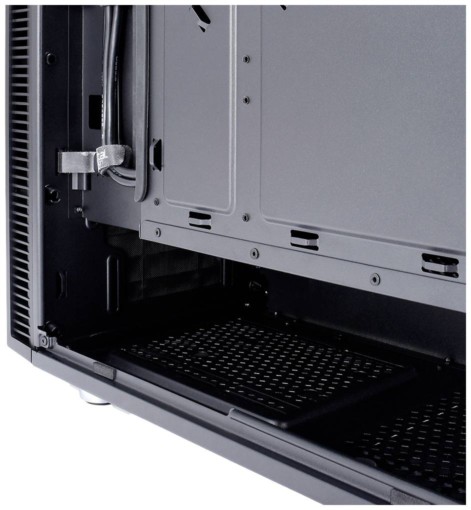 Egy fémből készült PC-torony belső tere, kábelrendező megoldásokkal és szellőzőnyílással, számítógépes komponensek beépítésére alkalmas.