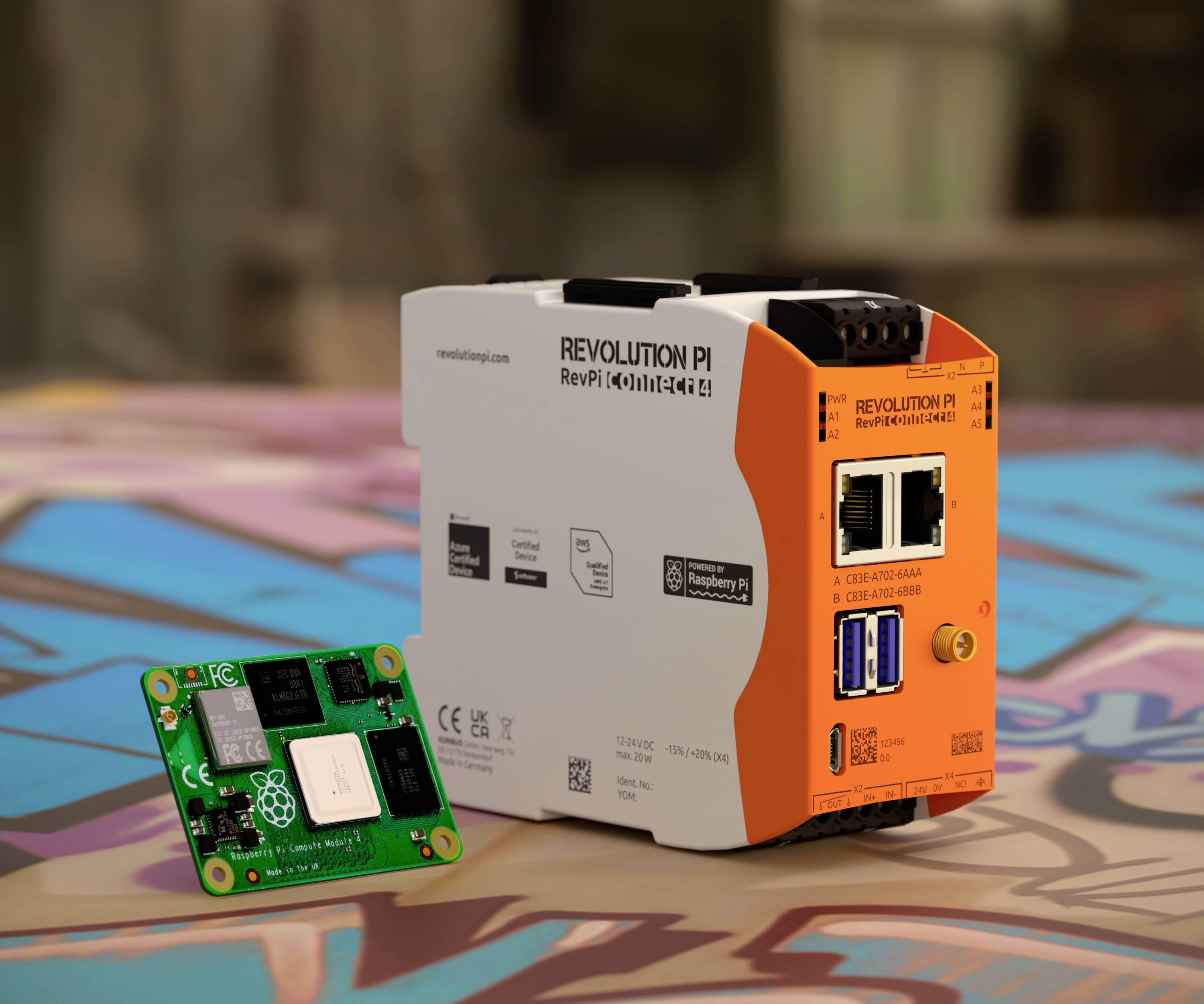 Ipari számítógép (Revolution Pi) Raspberry Pi Compute Modullal színes háttér előtt. Mindkét eszköz műszaki alkalmazásokra alkalmas.