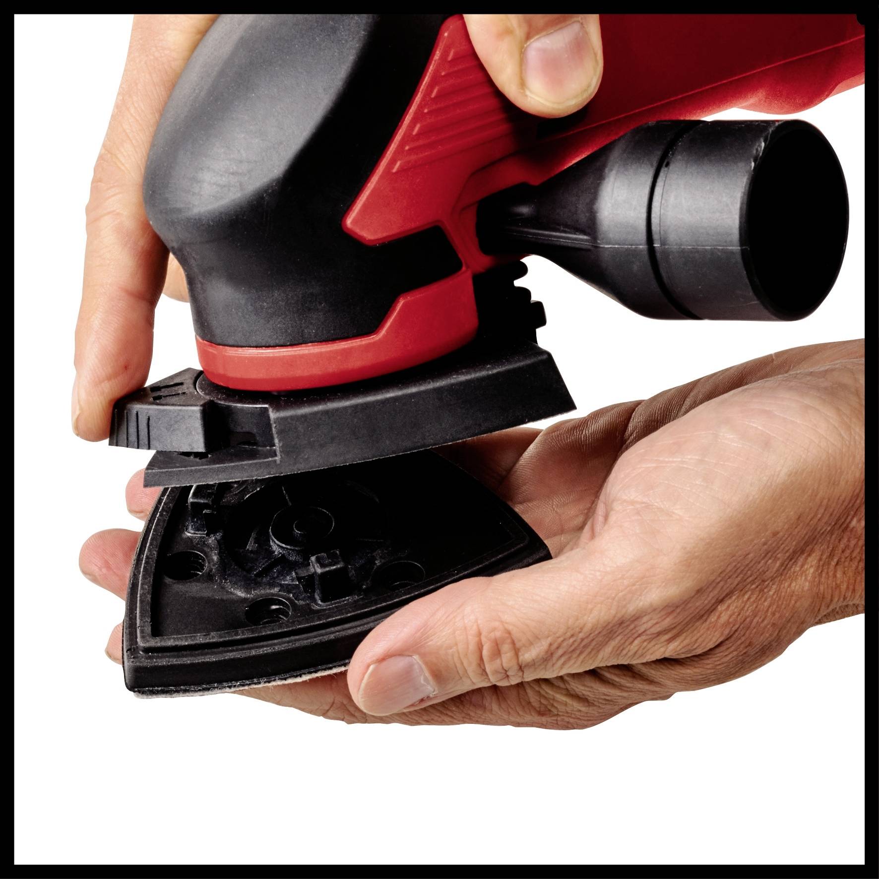Egy személy elektromos csiszolót tart, használatra készen, háromszög alakú csiszolólappal, fehér háttér előtt.