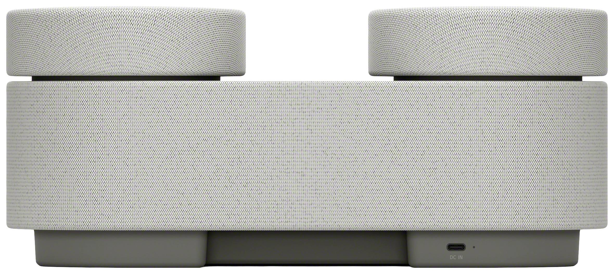 Modern, fehér hangszóró geometrikus dizájnnal és USB-csatlakozóval.