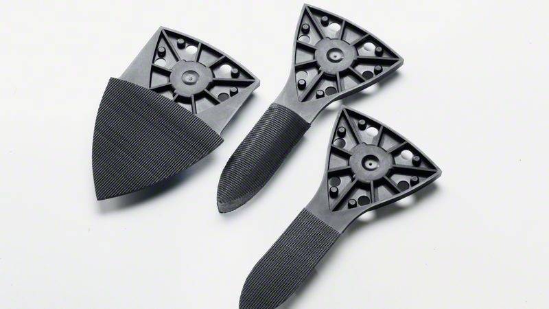 'Három fekete csiszolófej fehér háttéren. Mindegyiknek rombusz alakú csiszolófelülete és lekerekített fogantyúja van.'