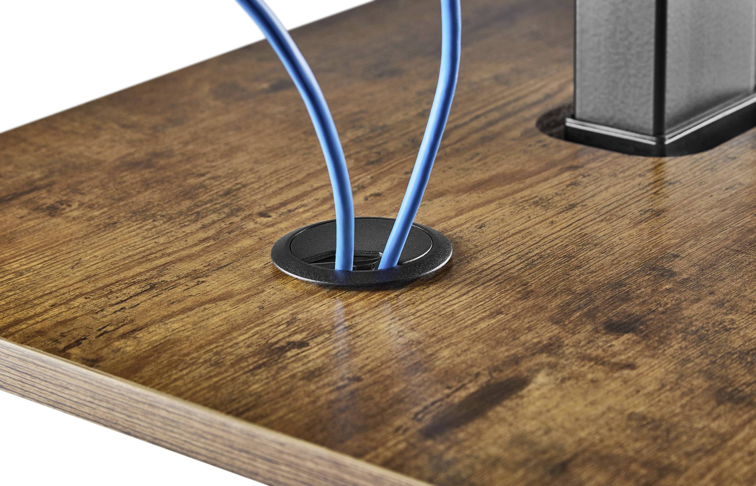 Kék kábelkötegelő vezet át több kábelt egy fafelület kábelbevezető nyílásán.