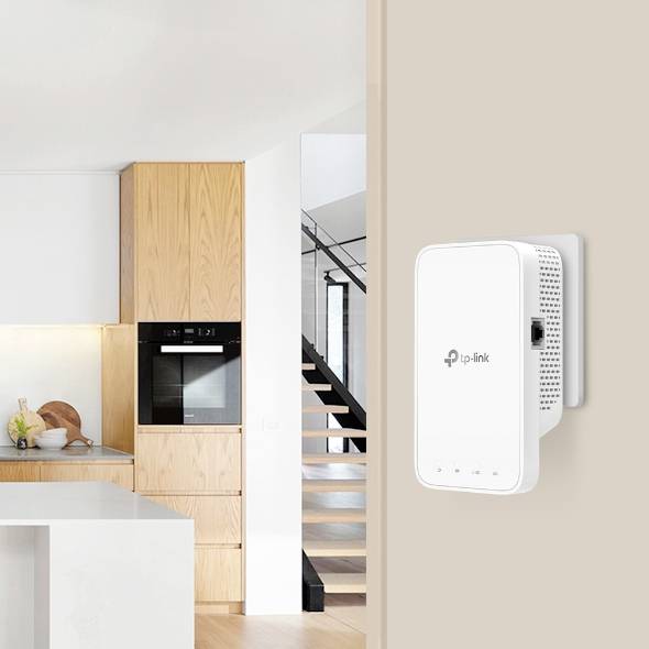Egy TP-Link mesh WiFi-erősítő egy modern, világos konyhában, a fali csatlakozóban fa szekrények és egy tűzhely mellett.