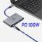 Egy laptop egy USB-C-kábellel egy szürke adapterhez csatlakozik, amely két USB-porttal és egy töltőcsatlakozóval rendelkezik. Szöveg: 'PD 100W'.