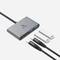 Egy USB-elosztó két USB-C és két USB-A csatlakozóval, egy hálózati adapterrel, egy USB-C és egy USB-A kábellel, mind szürke színben.