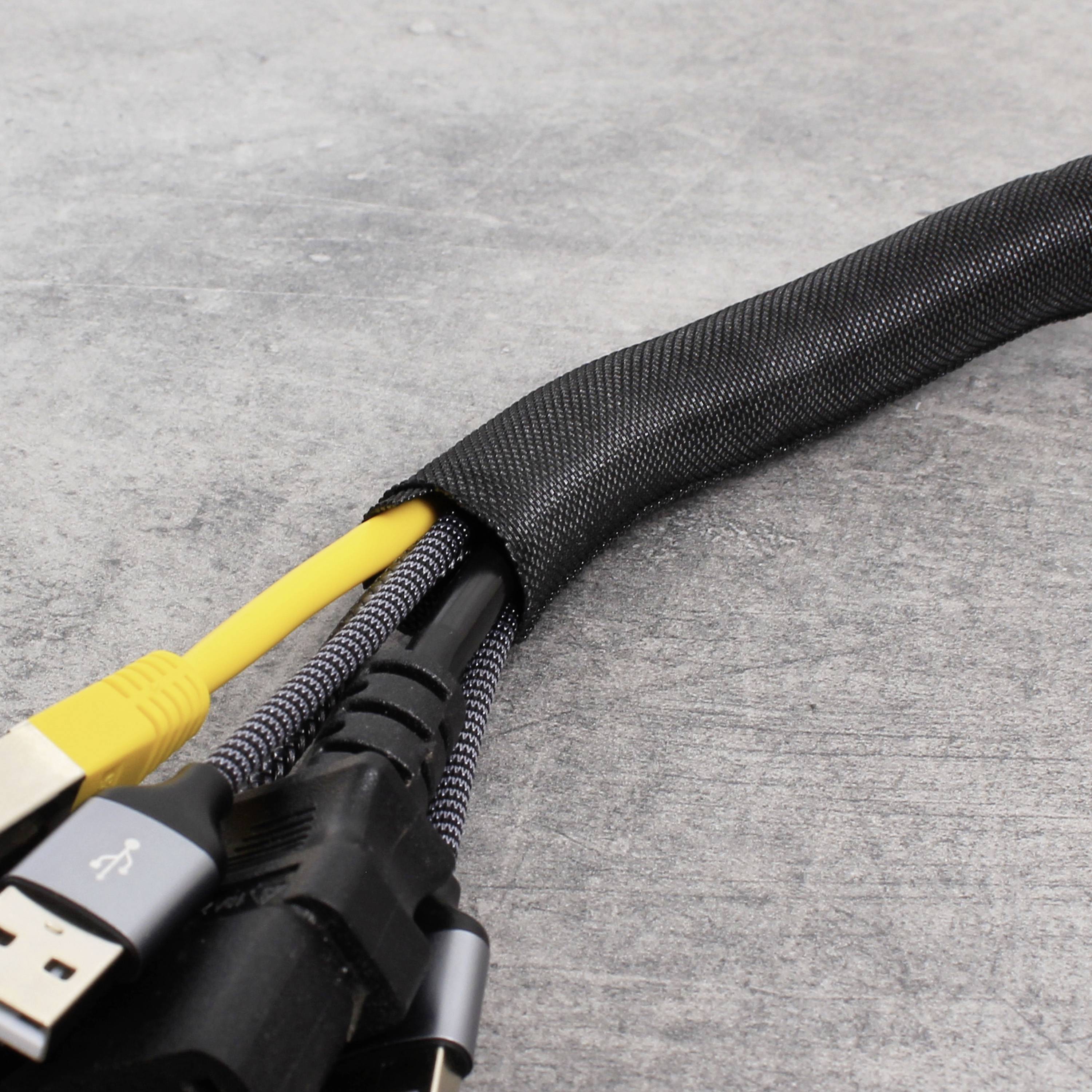 Egy elektromos kábelek köteget, benne egy szürke HDMI- és egy sárga USB-csatlakozóval, egy fekete kábelvédő csőben rendeztek el.