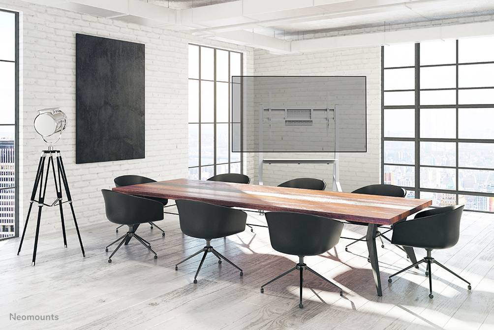 Egy modern tárgyalóterem nagy fa asztallal, hat fekete székkel, egy állvánnyal és egy üres fehér táblával a fal mentén.