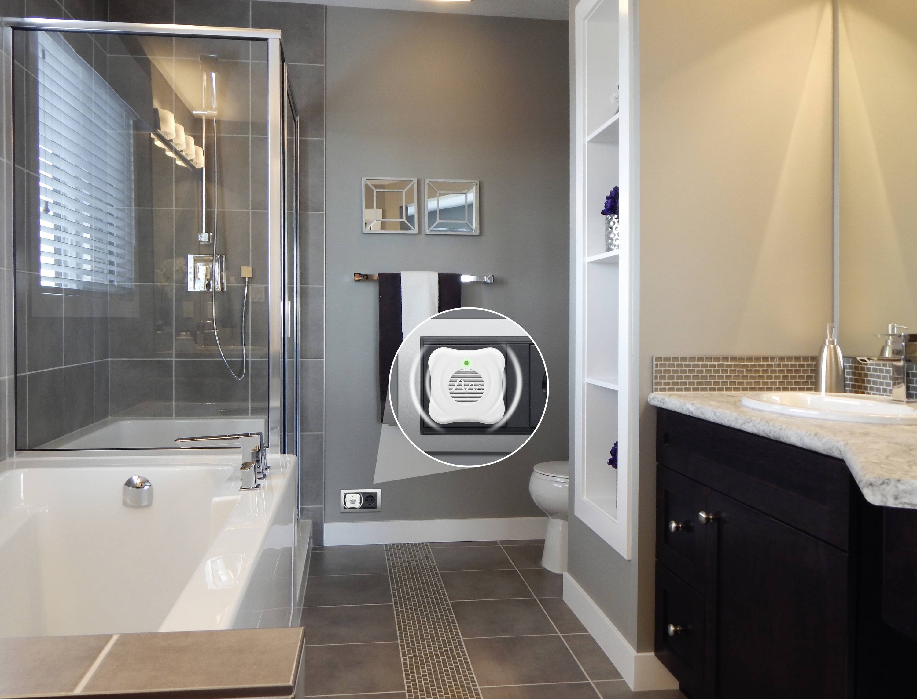 Egy modern fürdőszoba kád, mosdókagyló és WC-vel. Egy kisméretű levegőminőség-mérő eszköz van a falra szerelve.