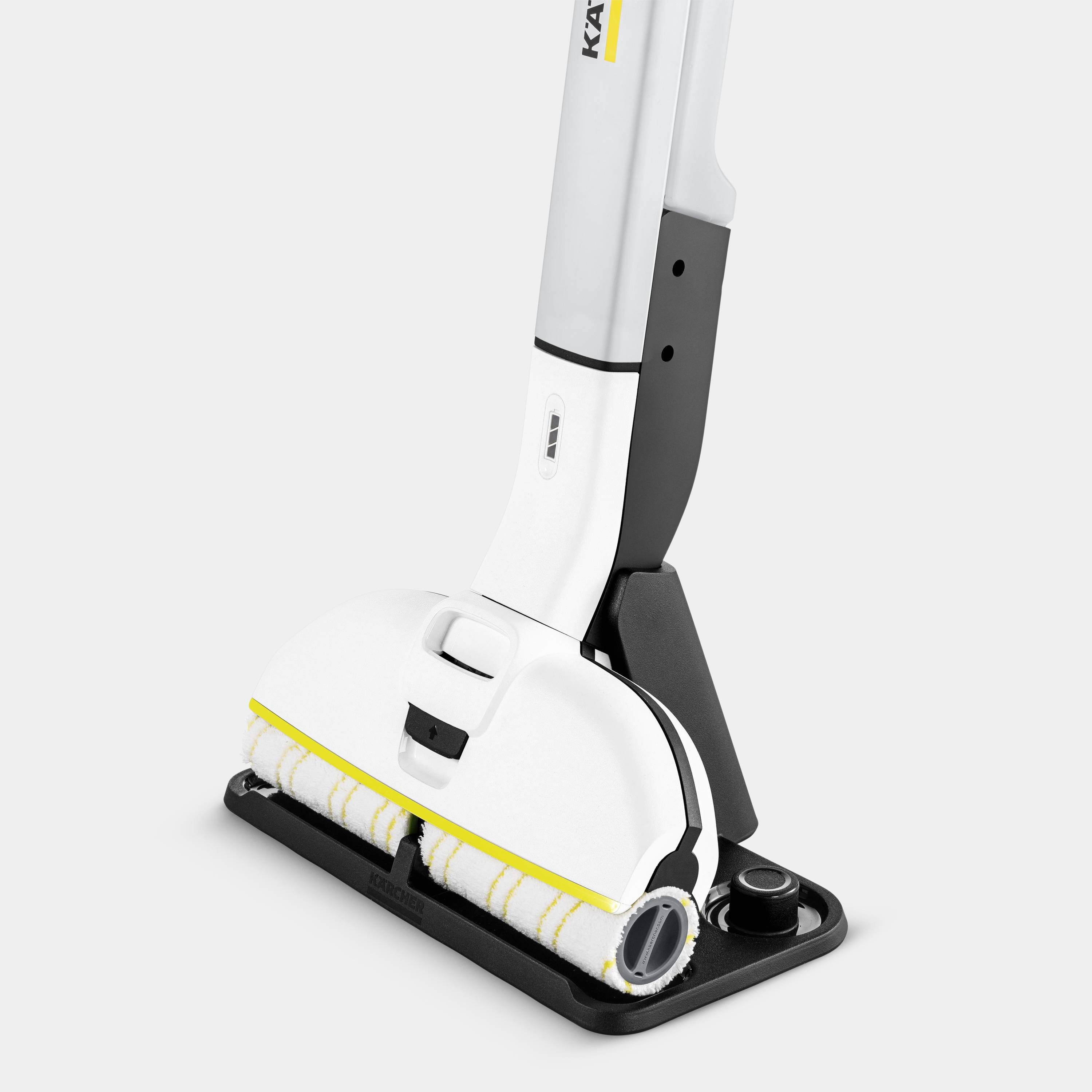 Egy elektromos padlótisztító két forgó kefével és ergonomikus fogantyúval, semleges környezetben ábrázolva.