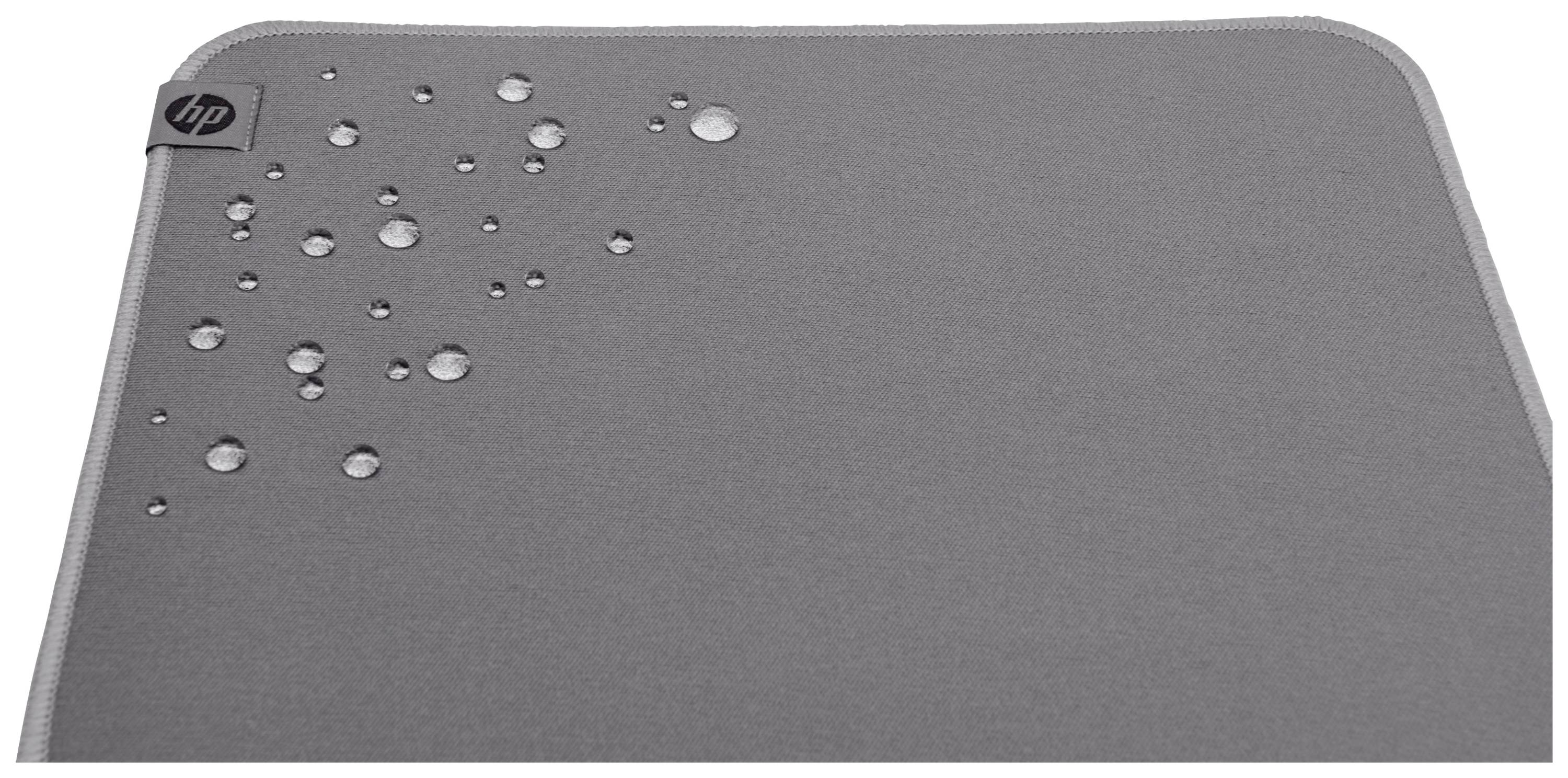 Egy szürke szövetpárna vízcseppekkel a felületén; bal felső sarokban egy kis logó látható.