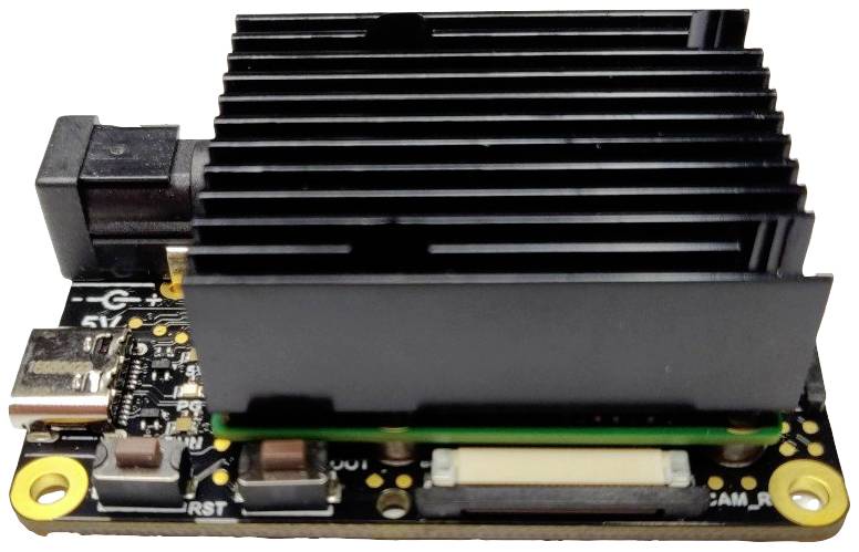 Egy egylapos számítógép hűtőbordával és több csatlakozóval, köztük USB és HDMI. Kompakt és alkalmas technikai projektekhez.