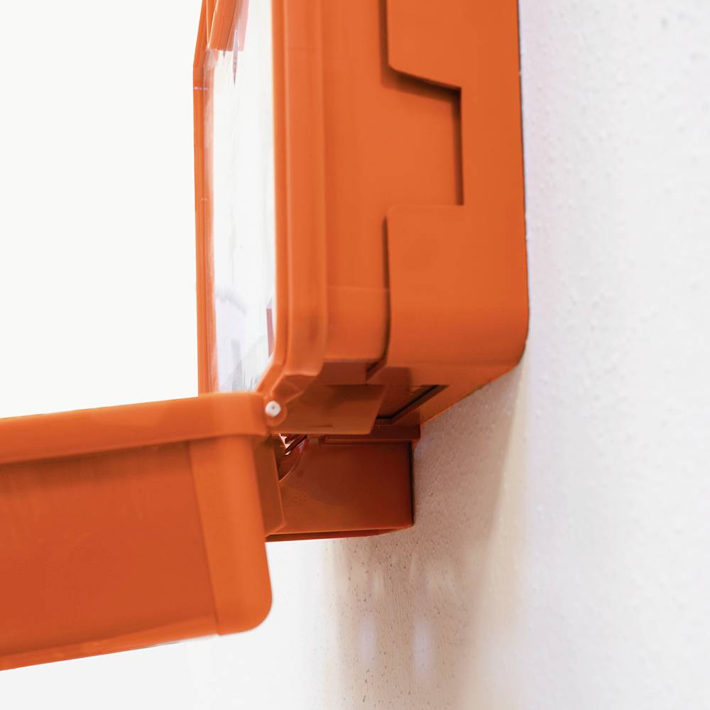 Egy narancssárga elsősegély-doboz egy fehér falon, részben kinyitva.