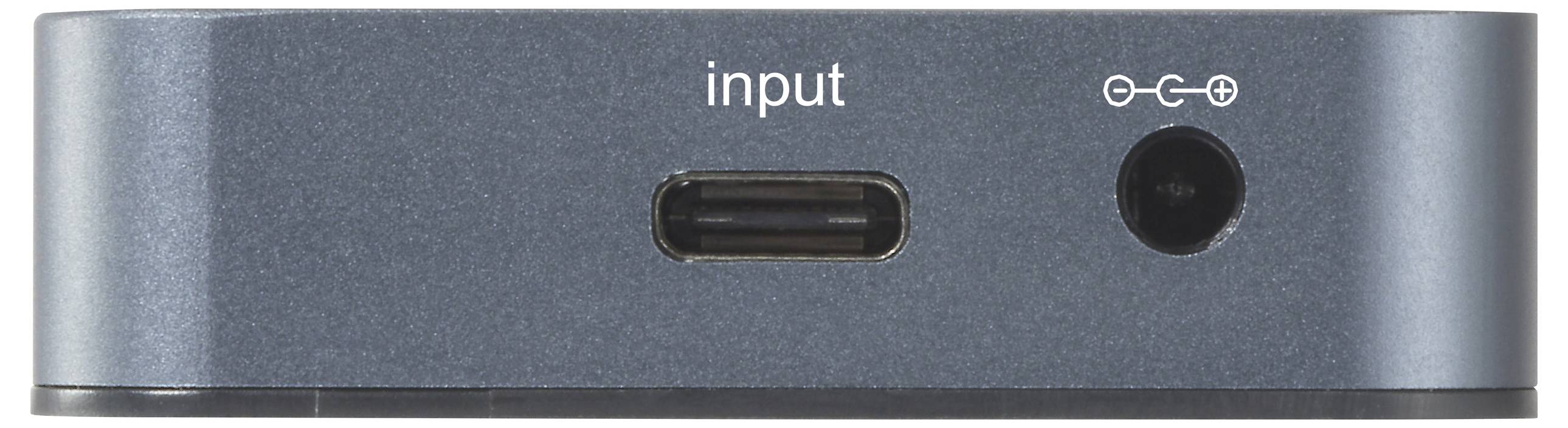 Fémszerkezetű eszköz USB-C bemenettel és hálózati csatlakozóval, elölről fotózva, amelyen az 'input' felirat látható a fontosabb csatlakozási pontok előterében.