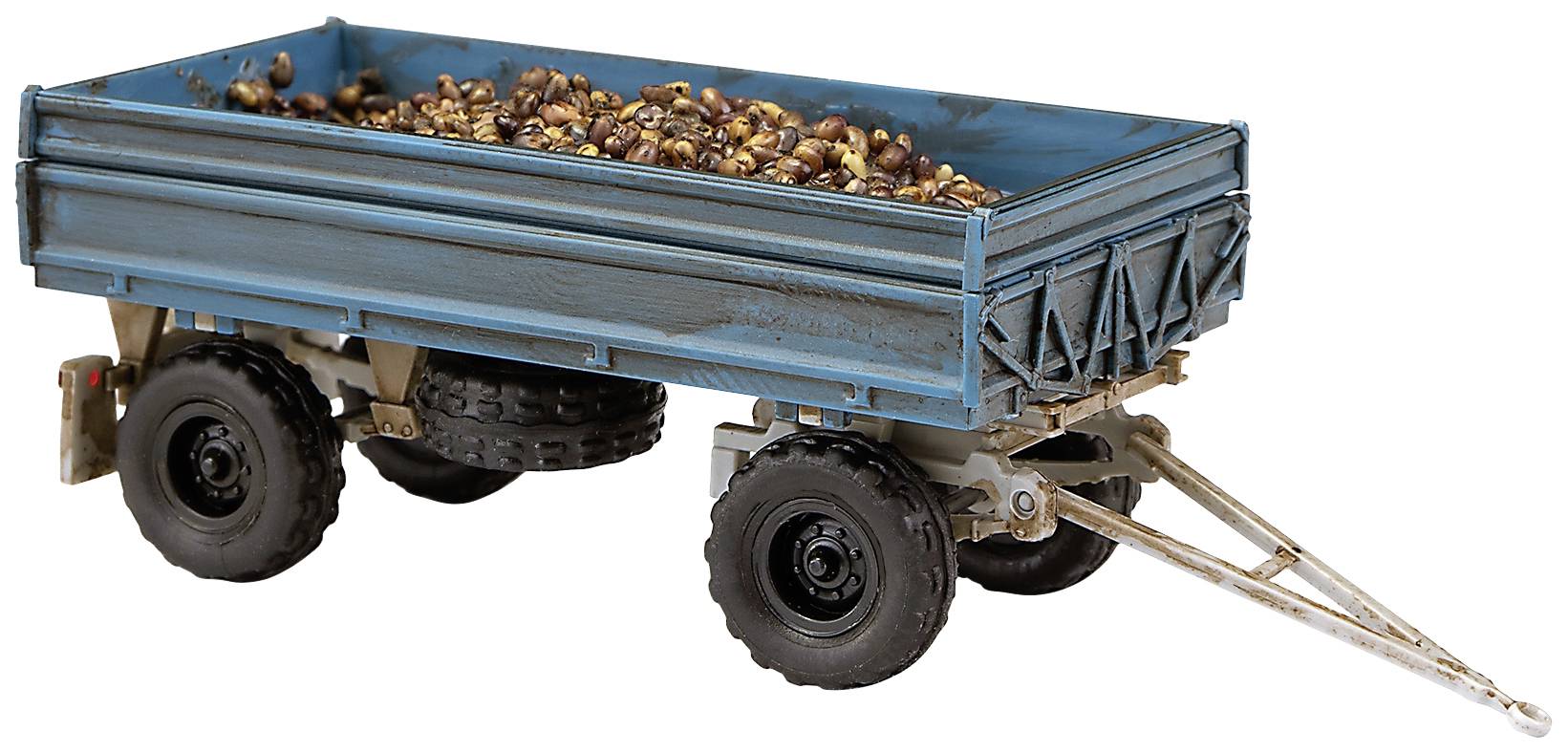 Egy kék utánfutó, tele gesztenyével, két tengely felett pihenve, egy vidéki szállítóeszközt mutat.