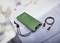 Zöld powerbank digitális akkumulátor-kapacitás kijelzővel, USB-töltőkábellel egy szürke felületen.
