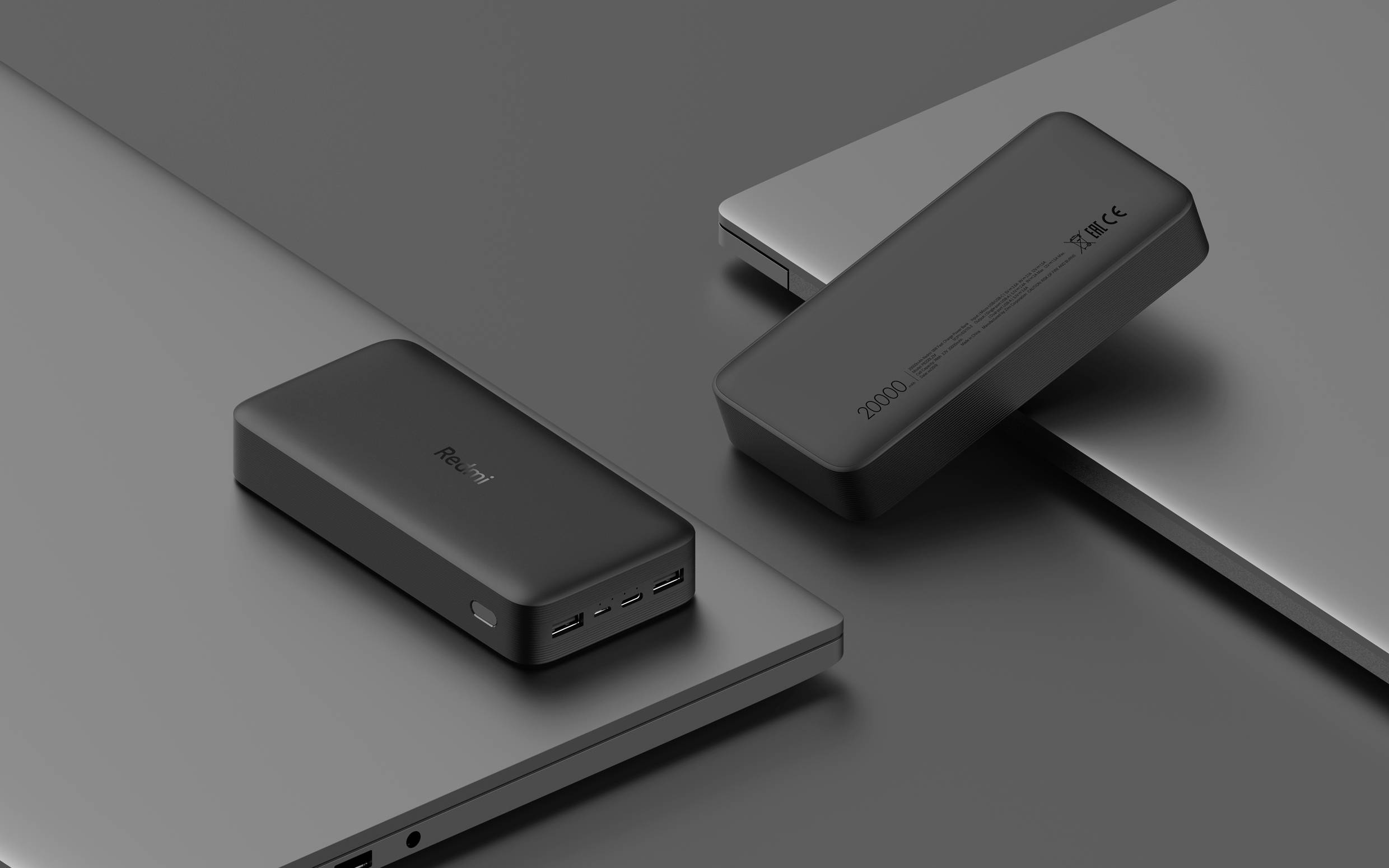 Két powerbank laptop tetején, az egyik 10000mAh felirattal. Mindkettőnek USB-csatlakozói vannak az elején. Minimalista dizájn.