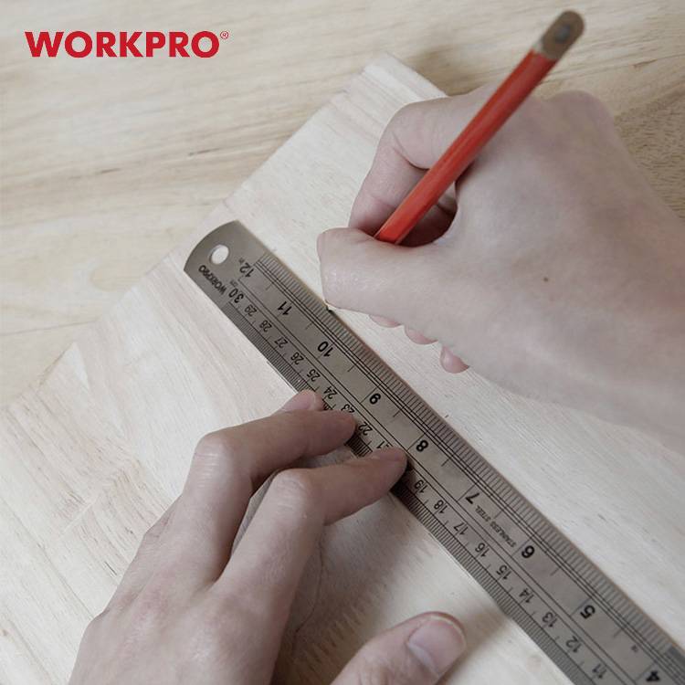 Egy kéz egy piros tollat tart, és egy vonalzóval mér egy fadeszkán. A háttérben 'WORKPRO' olvasható piros betűkkel.