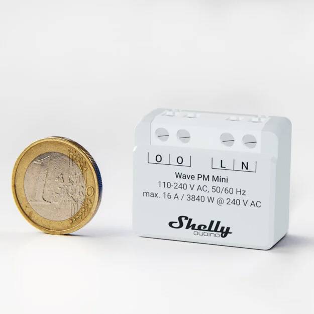 Egy euróérme egy fehér Shelly 1PM Mini eszköz mellett, amelyen elektromos specifikációk láthatók: 16 A, 3840 W, 240 V AC.