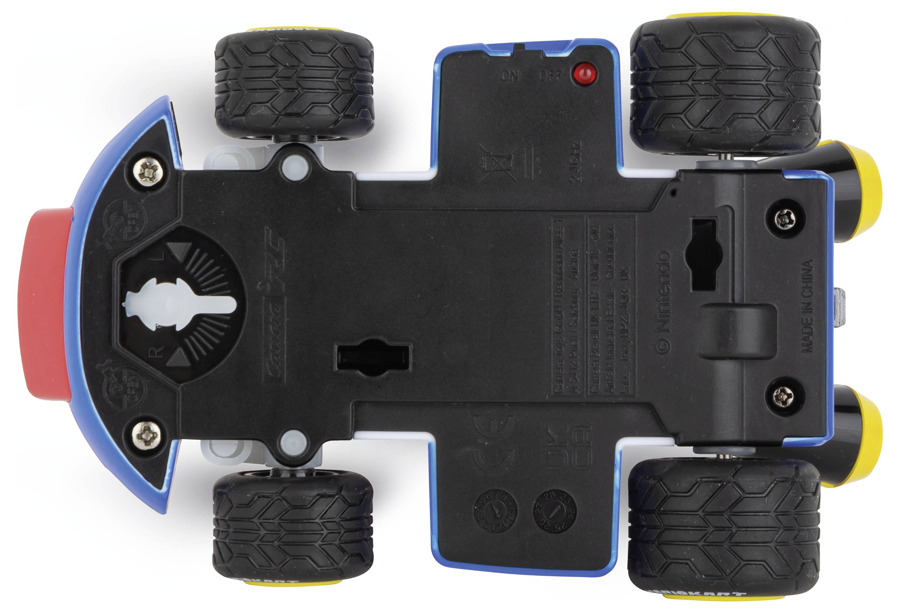 Játékautó alulnézetben, fekete kerekekkel és kék, valamint piros elemekkel a vázon.