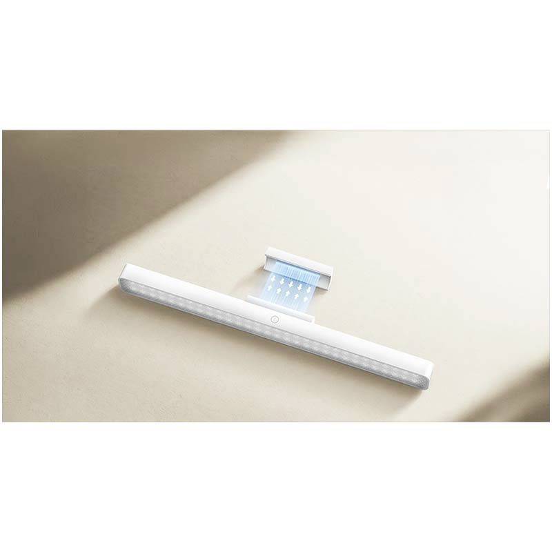 Egy lapos, fehér LED-lámpa minimalista esztétikával, amely egy téglalap alakú, bézs felületen fekszik.