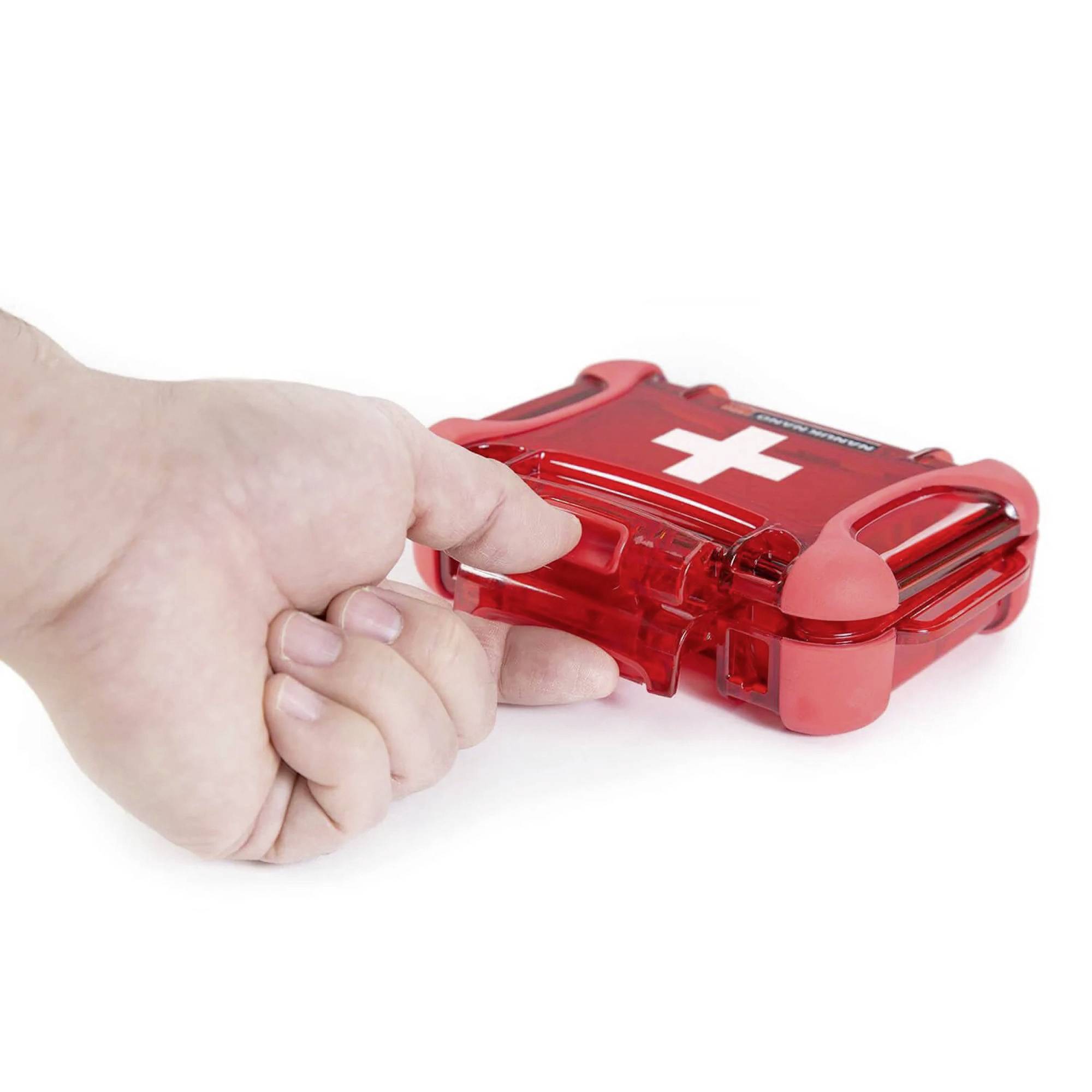 Egy kéz kinyit egy piros elsősegély-dobozt, amelynek a fedelén fehér kereszt látható.