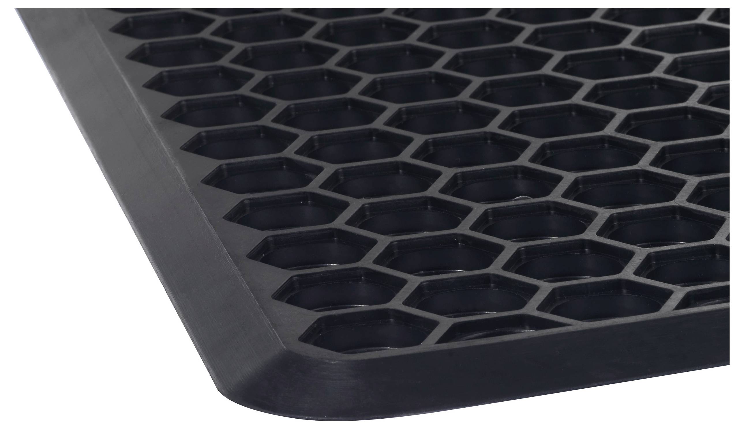 Egy fekete gumiszőnyeg közeli felvétele hatszögű mintázattal, amely csúszásmentes alátétként alkalmazható bejárati területeken.