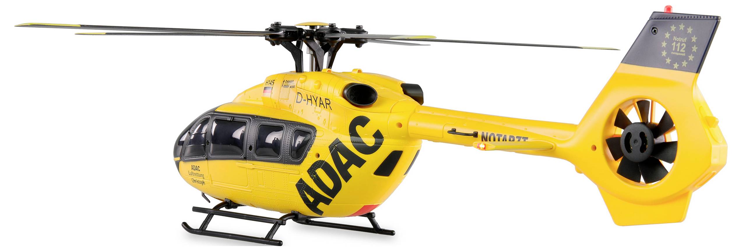 Sárga mentőhelikopter 'ADAC' felirattal az oldalán, a földön áll, sürgősségi esetek és gyors orvosi segítségnyújtás céljából.