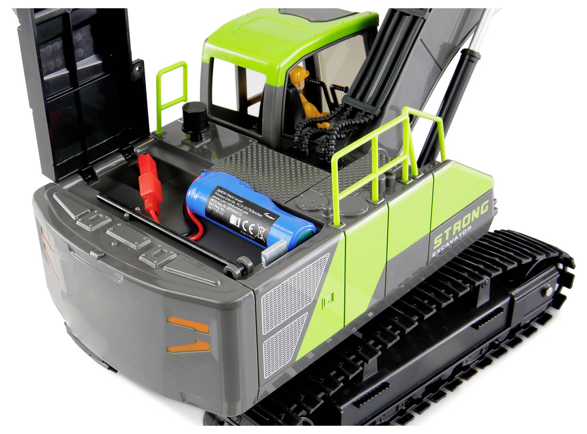Zöld és szürke játék markoló nyitott motortérrel, amelyben egy akkumulátor és kábelek láthatók. A sofőr figurája látszik a fülkében.