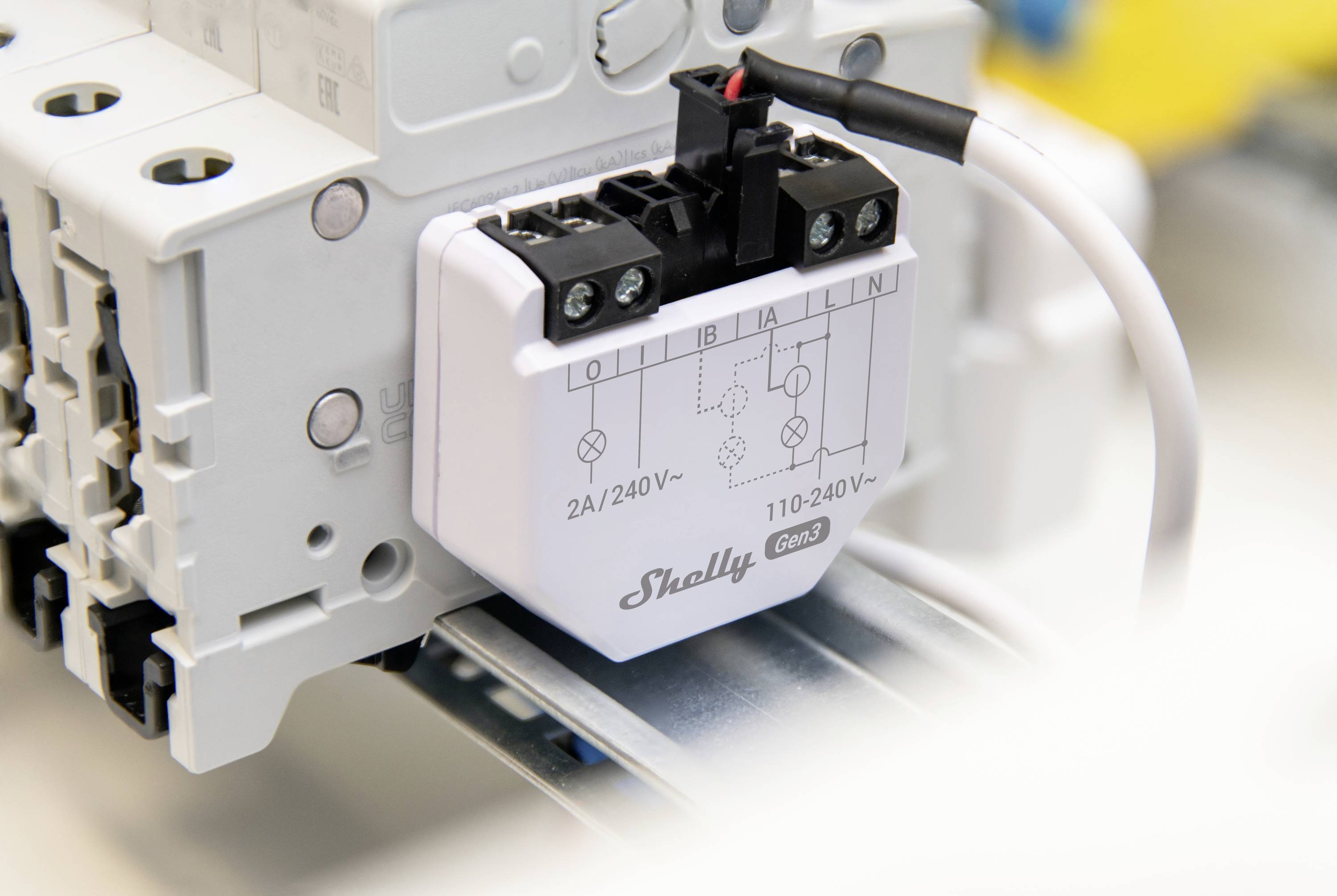 Egy elektromos relé modul, amelyen a 'Shelly 2A/240V' felirat szerepel. Áramkörök vezérlésére szolgál egy szerelősínen.