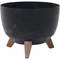 Egy kerek, fekete virágcserép három fa lábon.