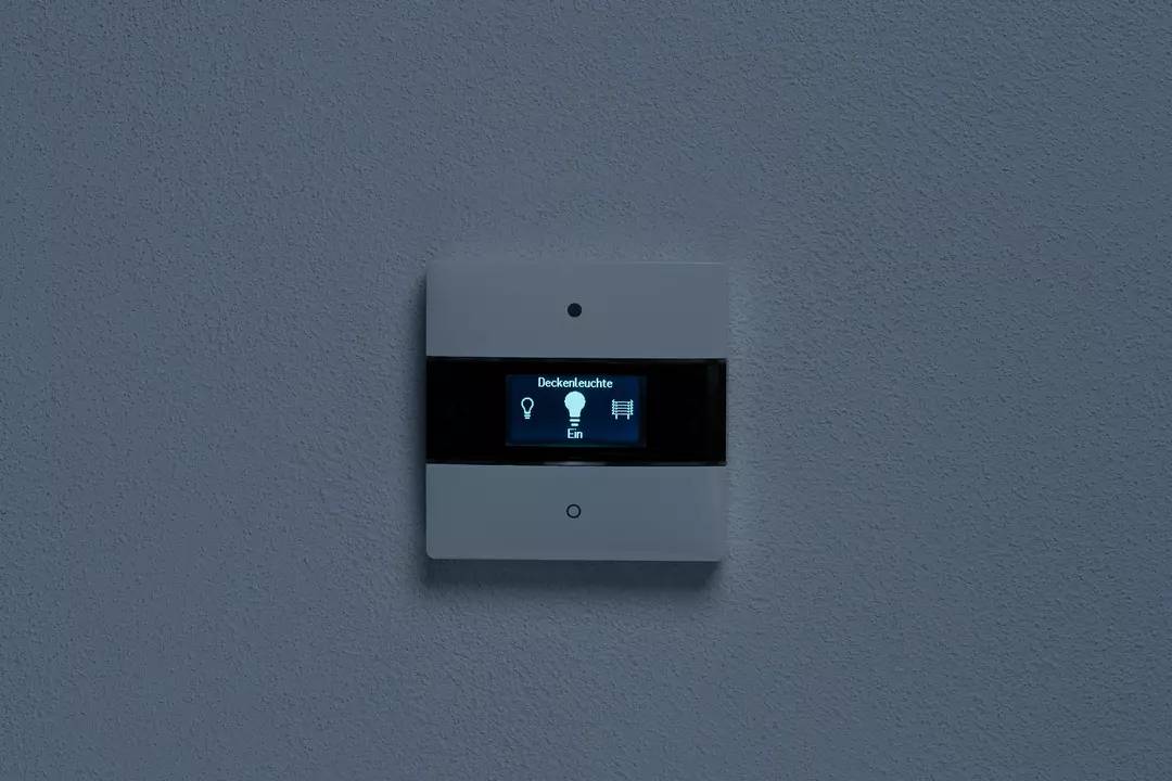 Fali kapcsoló digitális kijelzővel, amelyen az áll: 'Mennyezeti lámpa Bekapcsolva'.