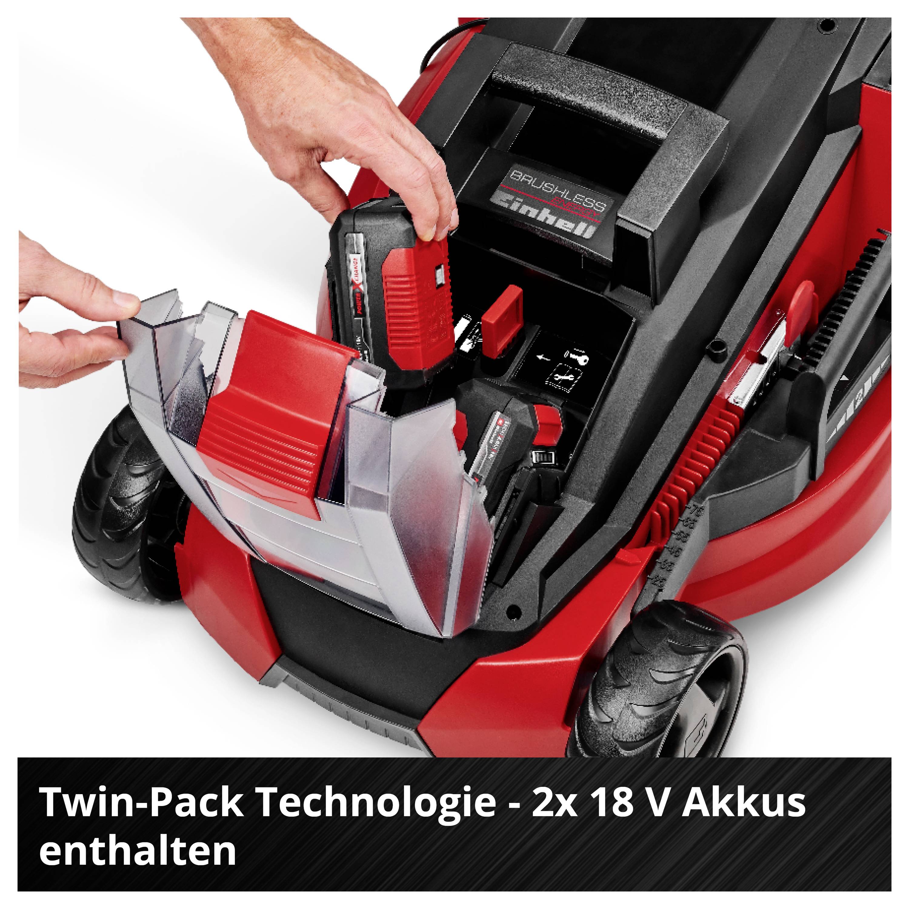 Az ember két 18 V-os akkumulátort helyez egy piros Einhell fűnyírógépbe; megjegyzés: "Twin-Pack technológia - 2x 18 V akkumulátor tartozék".