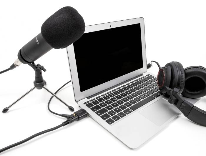 Laptop mikrofonnal és fejhallgatóval csatlakoztatva, készen áll hang felvételére vagy podcasting-re.